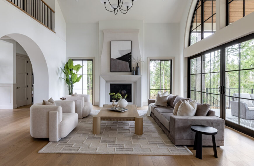 Vaulted great room with a fireplace, arched windows, and soft modern finishes in Plan 270109AF